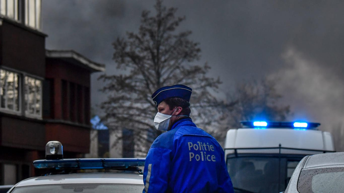 Ein Polizist steht vor der brennenden Waffelfabrik.