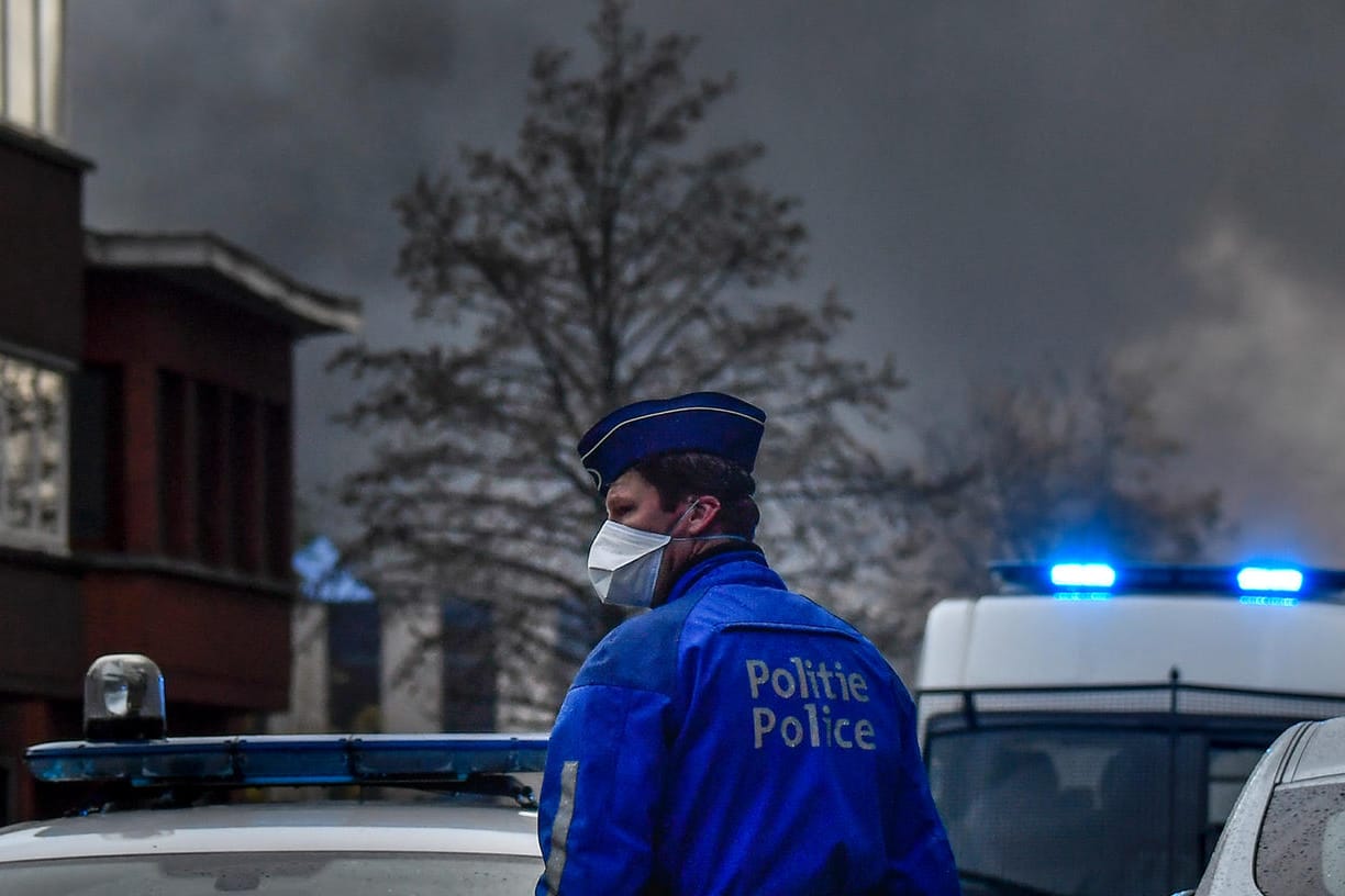 Ein Polizist steht vor der brennenden Waffelfabrik.