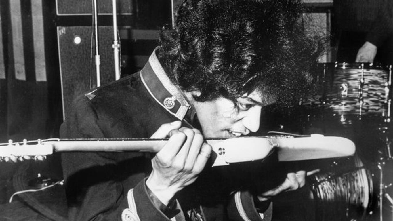 Jimi Hendrix spielt seine Gitarre auch mit der Zunge und den Zähnen.