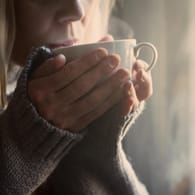 Eine Frau trinkt Kaffee: Kaffeegenuss hat viele Auswirkungen auf unseren Organismus.