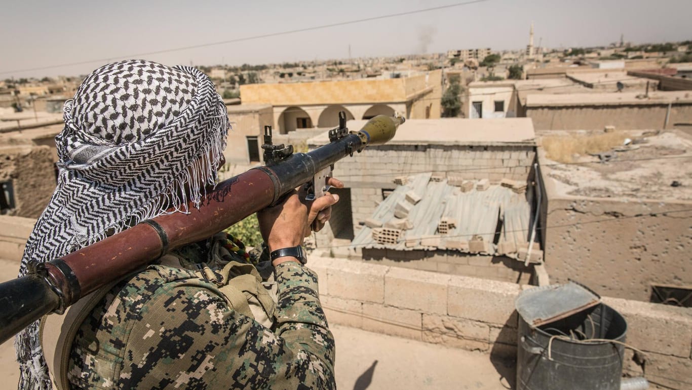 Ein Kämpfer der syrisch-kurdischen YPG-Miliz vor der Stadt Rakka im Juli: USA und Bundeswehr haben die Truppe mit Waffen beliefert.