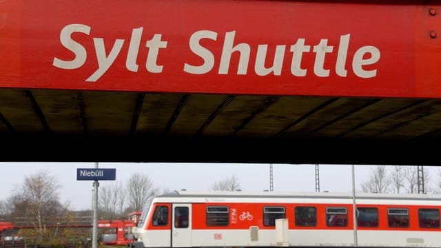 Ein Wagen des Autozuges "Sylt Shuttle" und ein Nahverkehrszug in Niebüll.