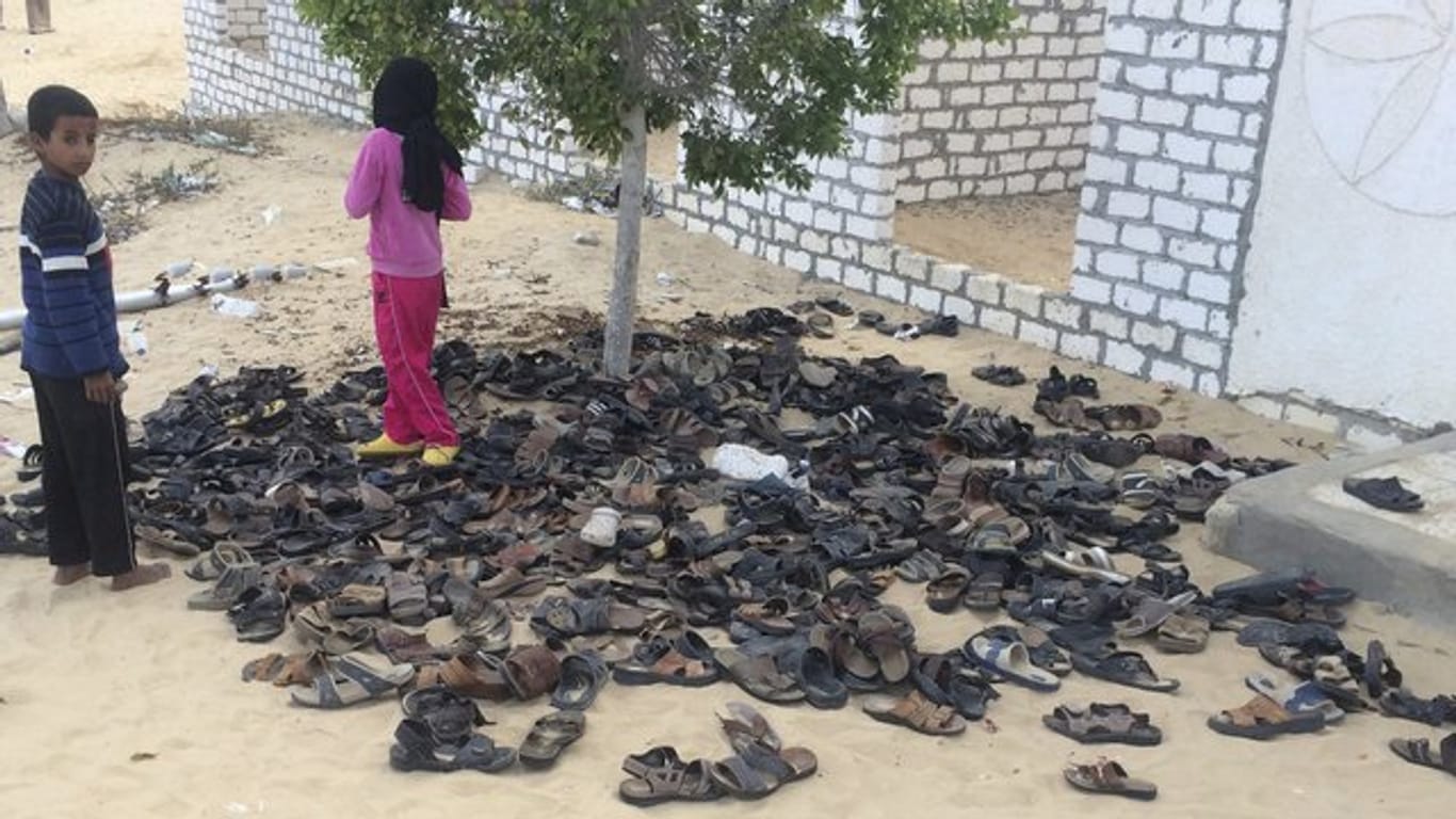 Kinder neben Schuhen von Opfern des verheerenden Terroranschlags auf die Moschee.