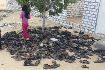 Kinder neben Schuhen von Opfern des verheerenden Terroranschlags auf die Moschee.