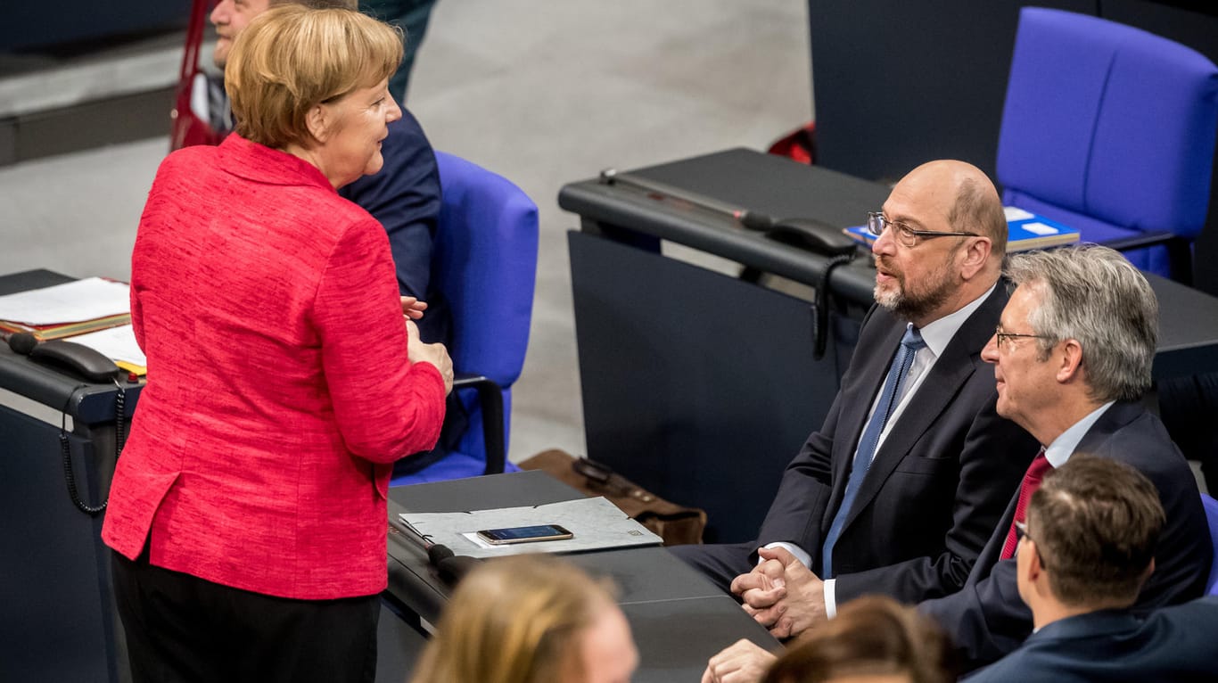 Kanzlerin Angela Merkel spricht im Bundestag mit Martin Schulz: Besonders sozialpolitische Streitpunkte könnten verhindern, dass es zu einer Neuauflage der Großen Koalition kommt.