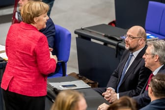 Kanzlerin Angela Merkel spricht im Bundestag mit Martin Schulz: Besonders sozialpolitische Streitpunkte könnten verhindern, dass es zu einer Neuauflage der Großen Koalition kommt.