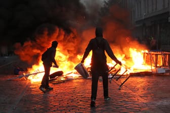 Randalierer stehen am 07.07.2017 im Schanzenviertel in Hamburg vor einer brennenden Barrikade. Am 28.09.2017 werden zwei weitere Prozesse wegen der G-20-Ausschreitungen in Hamburg verhandelt