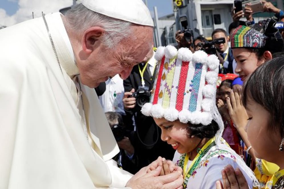 Papst Franziskus wird in Yangon von Kindern in traditioneller Kleidung begrüßt.