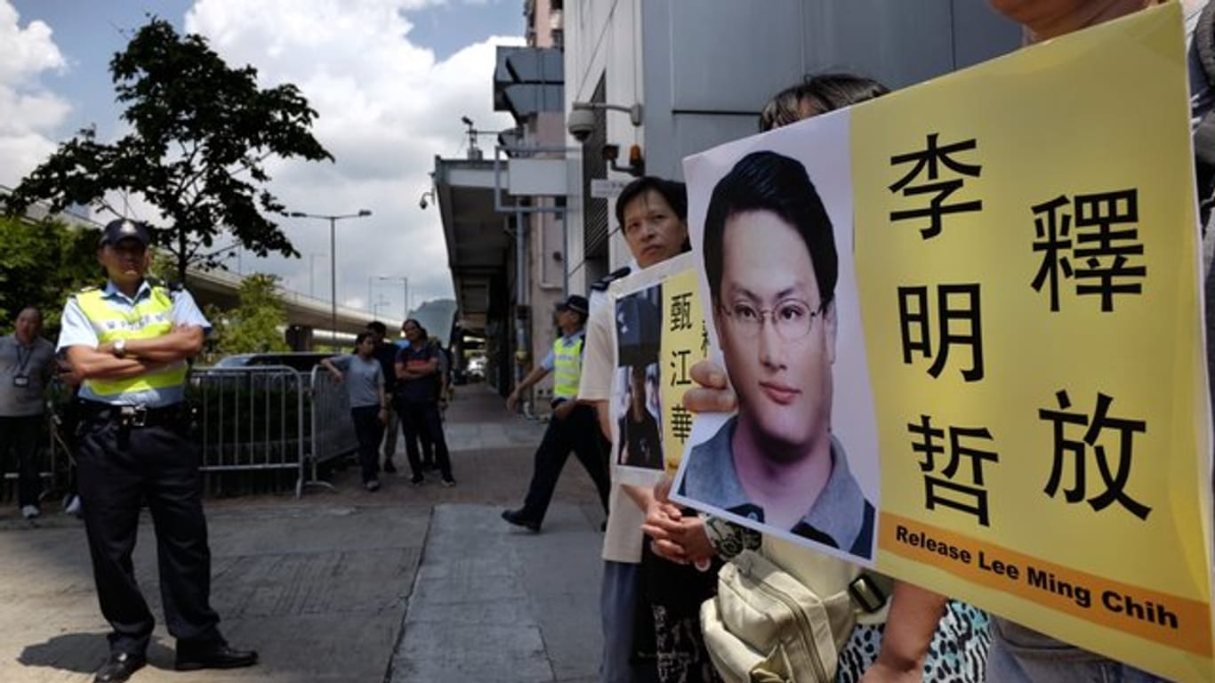 Demonstranten in Hongkong mit Fotos des Menschenrechtsaktivisten Lee Ming-che.