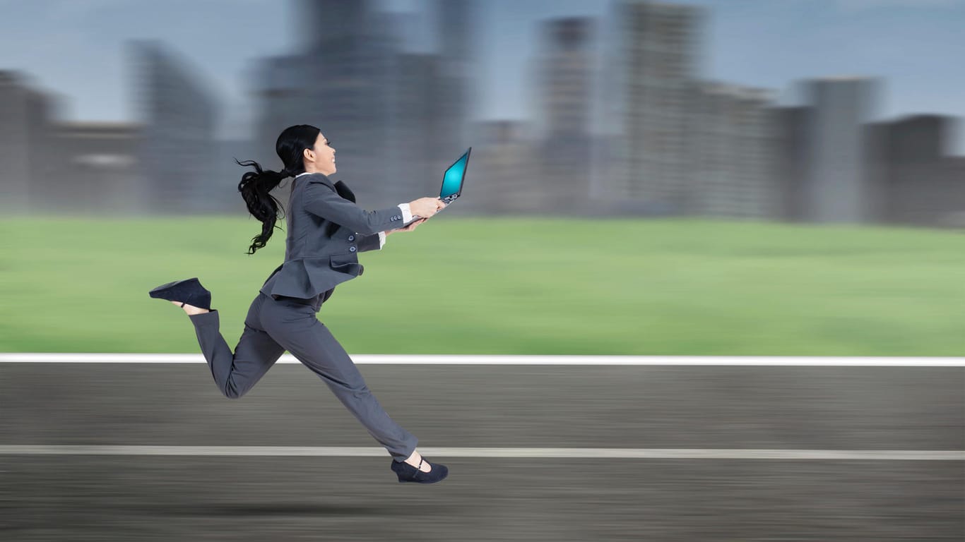 Frau rennt mit Laptop