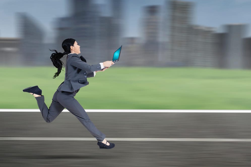 Frau rennt mit Laptop