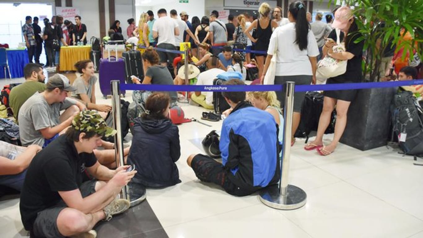 Touristen warten am Flughafen in Denpasar darauf, dass wieder Flüge von Bali aus starten.