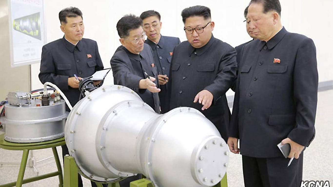 Machthaber Kim Jong Un (M.) mit Militärtechnikern, März 2016: Westliche Experten bewerten den angeblich raketenfähigen Nuklearsprengkopf als Attrappe.
