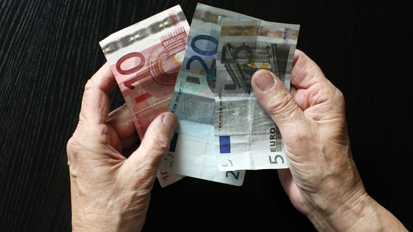Älterer Mensch hält Geldscheine in der Hand