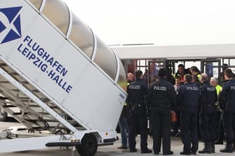 Polizisten überwachen eine Sammelabschiebung auf dem Flughafen Leipzig-Halle.