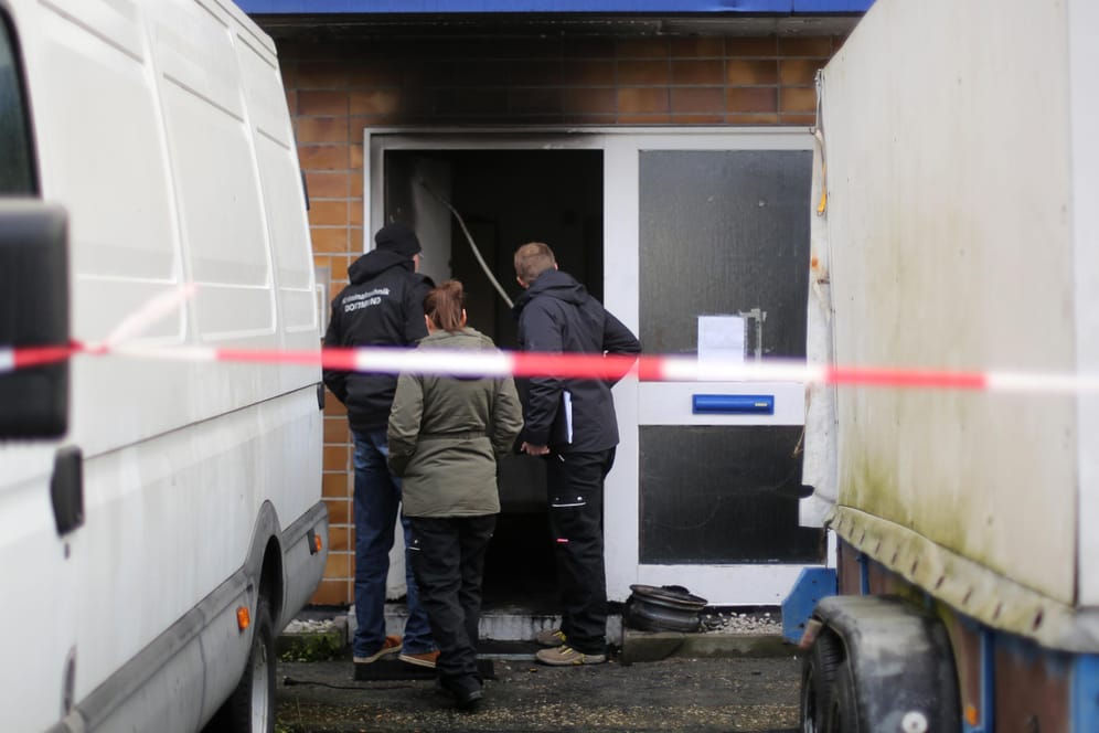 Kriminaltechniker begutachten den Eingang zu einem Haus nach einem Brand