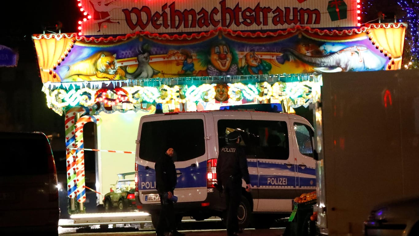 Polizisten auf einem Potsdamer Weihnachtsmarkt: Ermittler suchen die Umgebung nach weiteren Sprengsätzen ab.