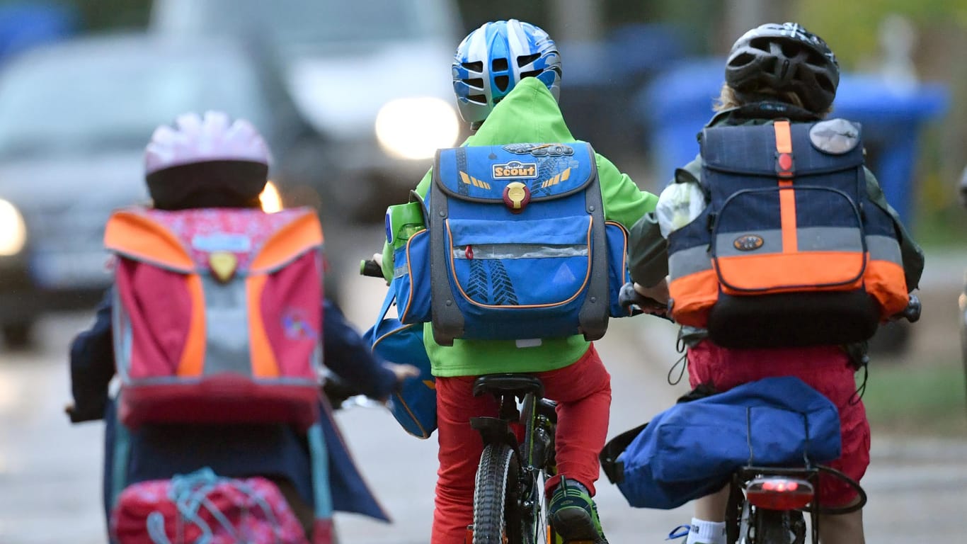 Kinder sind mit dem Fahrrad zur Schule unterwegs.