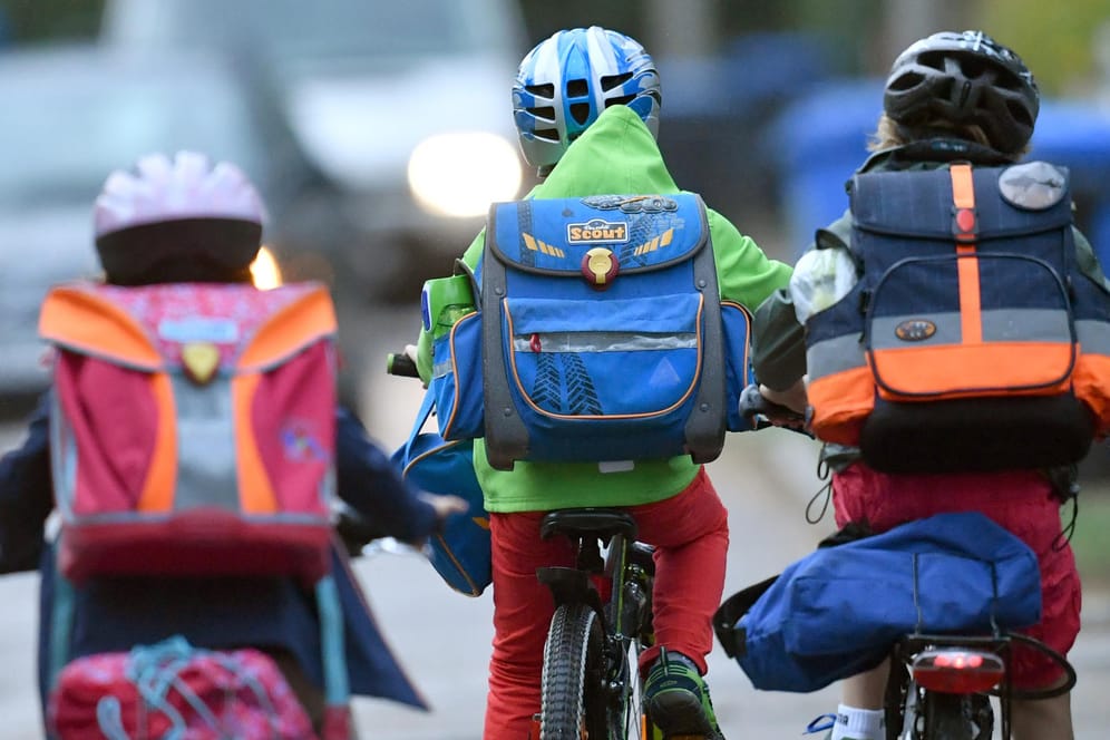 Kinder sind mit dem Fahrrad zur Schule unterwegs.