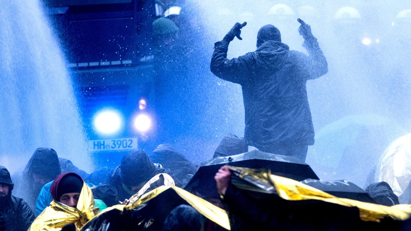 Ein AfD-Gegner gestikuliert während eines Wasserwerfer-Einsatzes in Richtung der Polizei.