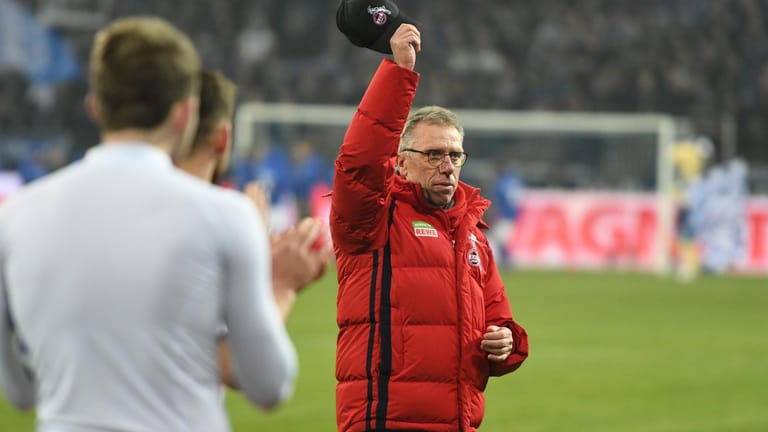 Peter Stöger zieht seine Mütze vor den FC-Fans nach einem der besten Auftritte der Kölner in dieser Saison beim 2:2 auf Schalke.