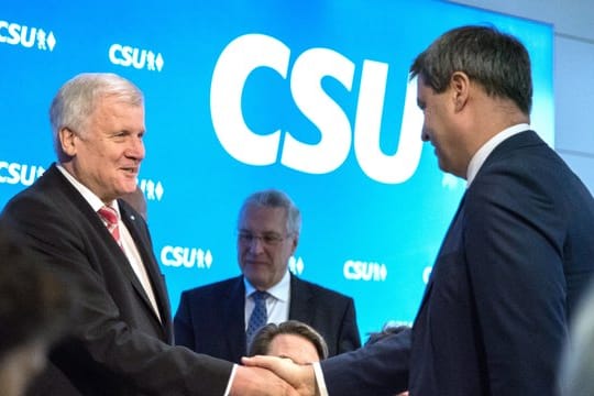 Der bayerische Ministerpräsident Horst Seehofer und sein designierter Nachfolger Markus Söder (r) geben sich die Hand.