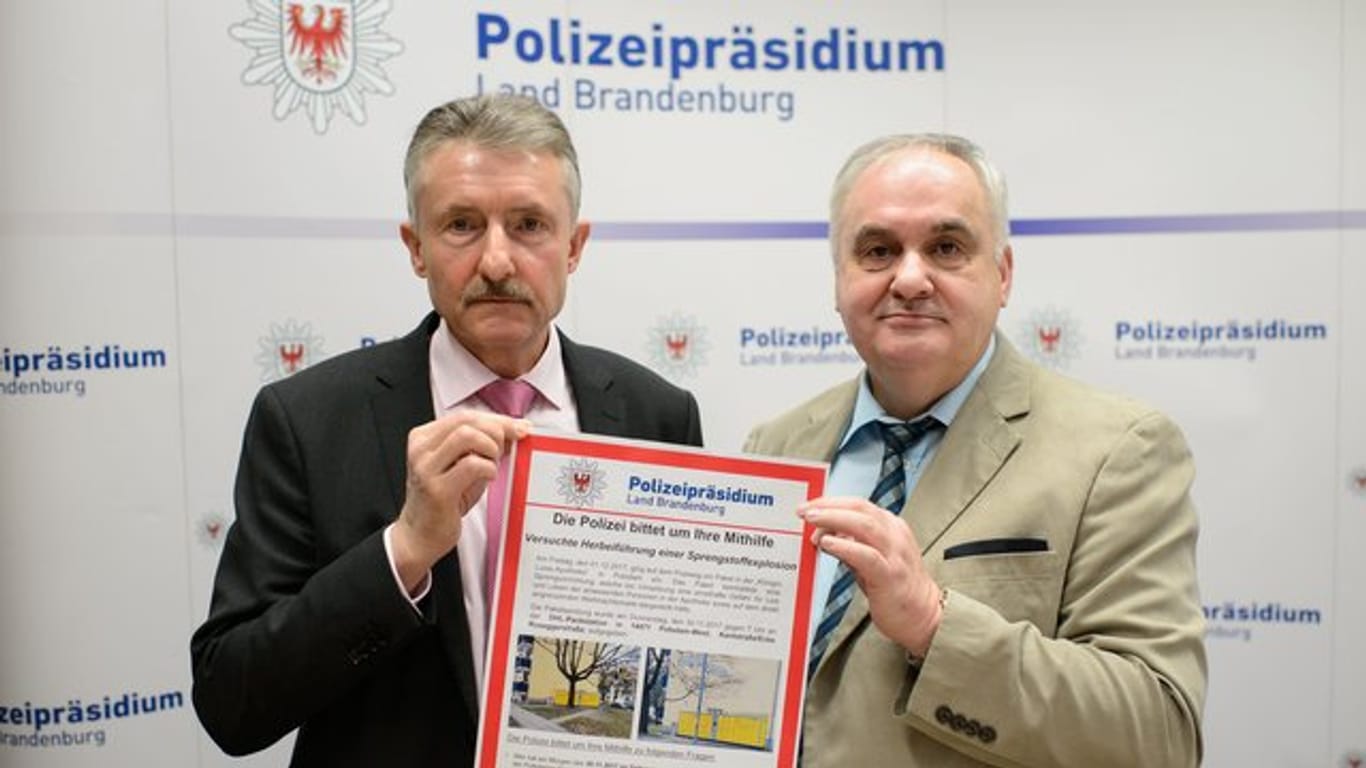 Brandenburgs Innenminister Karl-Heinz Schröter (l) und Polizeipräsident Hans-Jügen Mörke halten in Potsdam ein Fahndungsplakat in die Höhe.