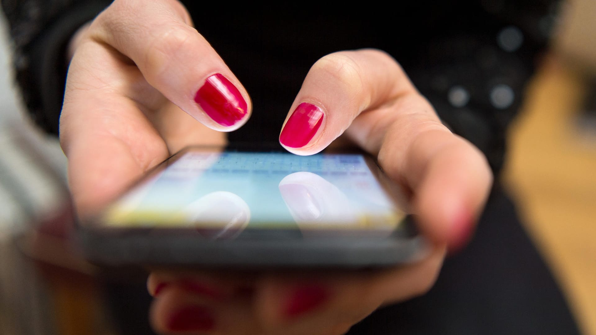 Frau tippt auf einem Smartphone