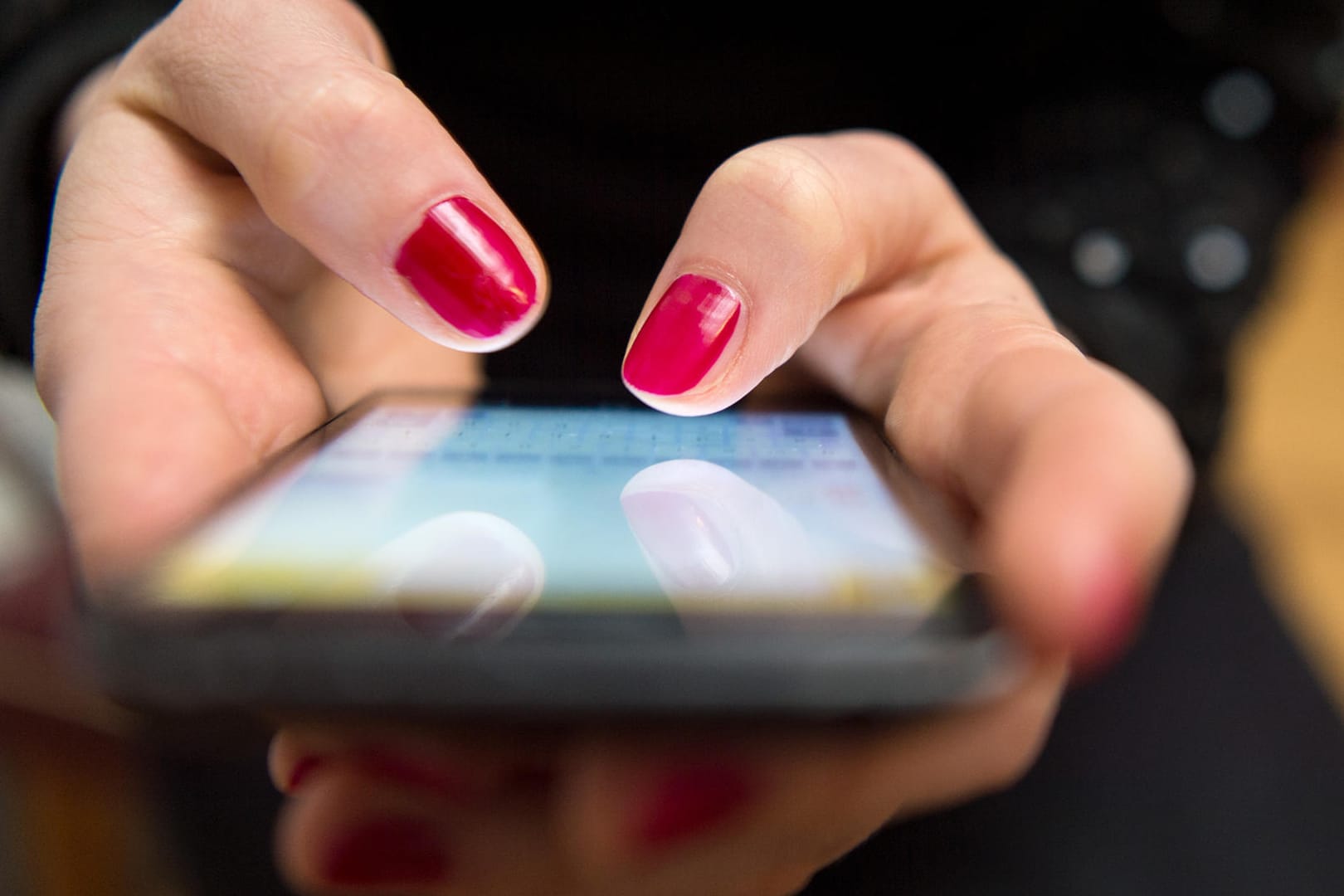 Frau tippt auf einem Smartphone