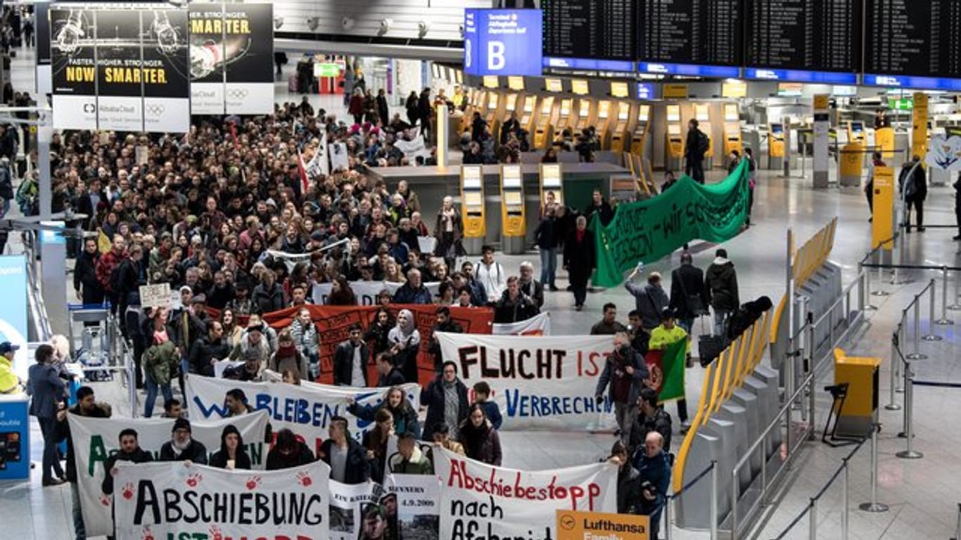 Aktivisten verschiedener Organisationen demonstrieren im Frankfurter Flughafen gegen den Abschiebeflug nach Afghanistan.