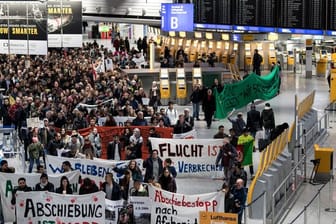 Aktivisten verschiedener Organisationen demonstrieren im Frankfurter Flughafen gegen den Abschiebeflug nach Afghanistan.