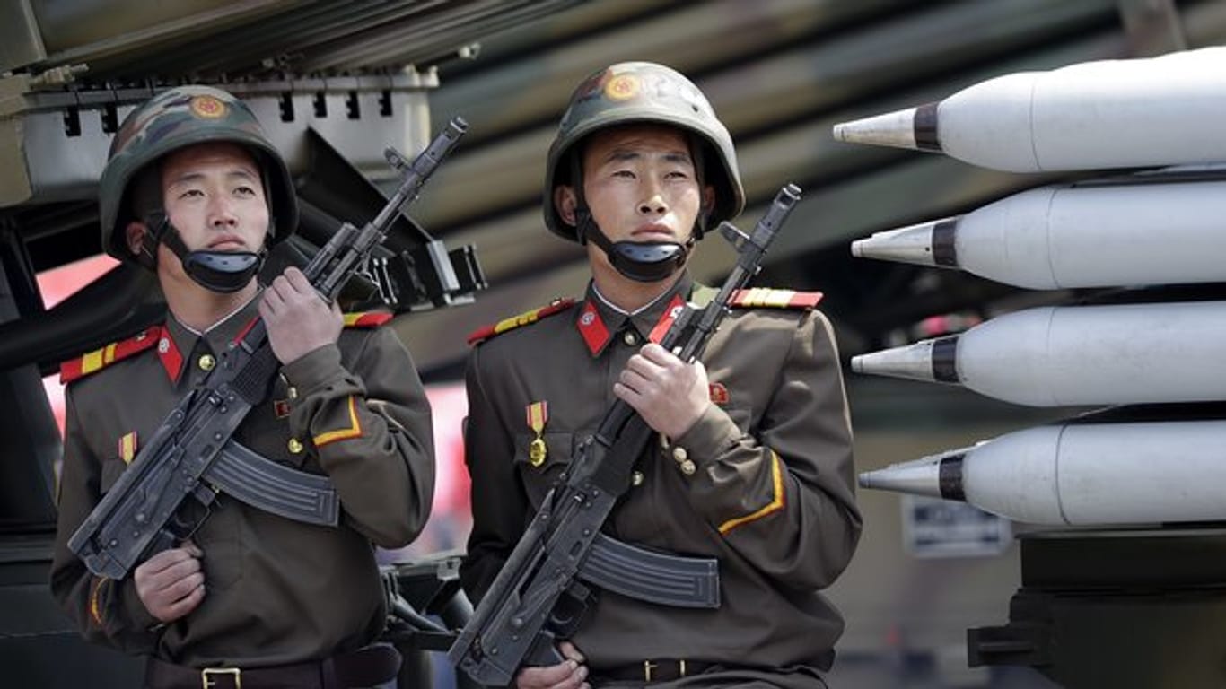 Zwei nordkoreanische Soldaten sitzen bei einer Militärparade in Pjöngjang auf einem mobilen Raketenwerfer.