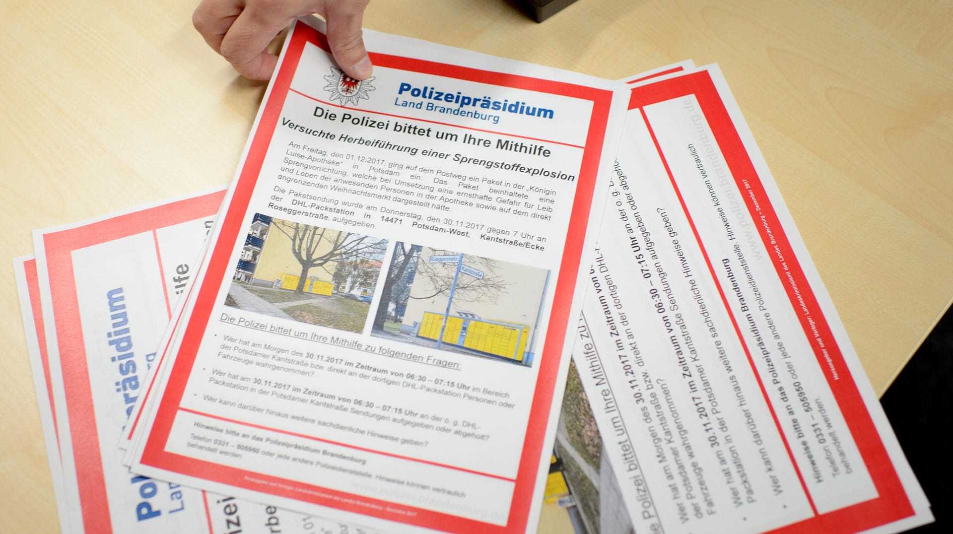 Ein Mitarbeiter der Polizei Brandenburg legt Fahndungsplakate im Polizeipräsidium in Potsdam nach einer Pressekonferenz zur Potsdamer Paketbombe aus.