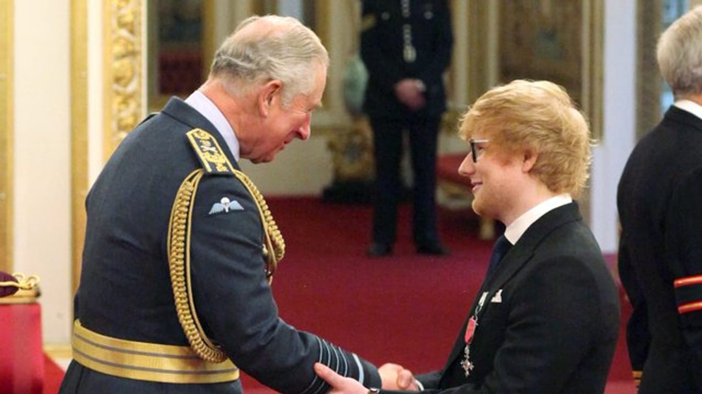 Der britische Musiker Ed Sheeran (r) schüttelt Prinz Charles die Hand.