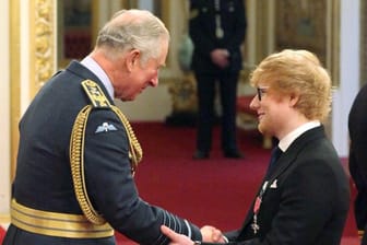 Der britische Musiker Ed Sheeran (r) schüttelt Prinz Charles die Hand.