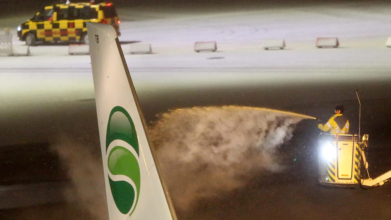 Flughafen Hamburg: Eine Maschine der Fluggesellschaft Germania wird bei Schneetreiben am späten Sonntagabend enteist.