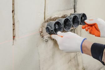 Stromanschluss an unverputzter Wand: Stromleitungen sollten stets von einem Fachmann verlegt werden.