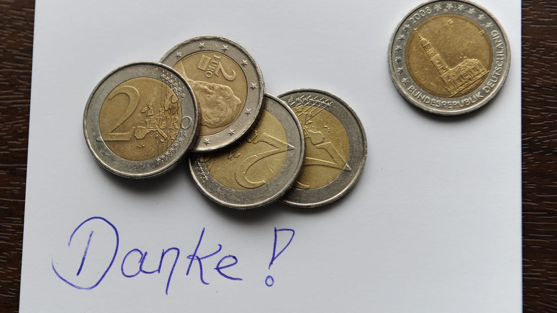 Geld auf einem Zettel mit dem Schriftzug "Danke!": Trinkgeld ist die freiwillige Leistung eines Gastes. Auch auf Kreuzfahrten müssen Reisende daher selbst entscheiden können, ob sie es bezahlen oder nicht.