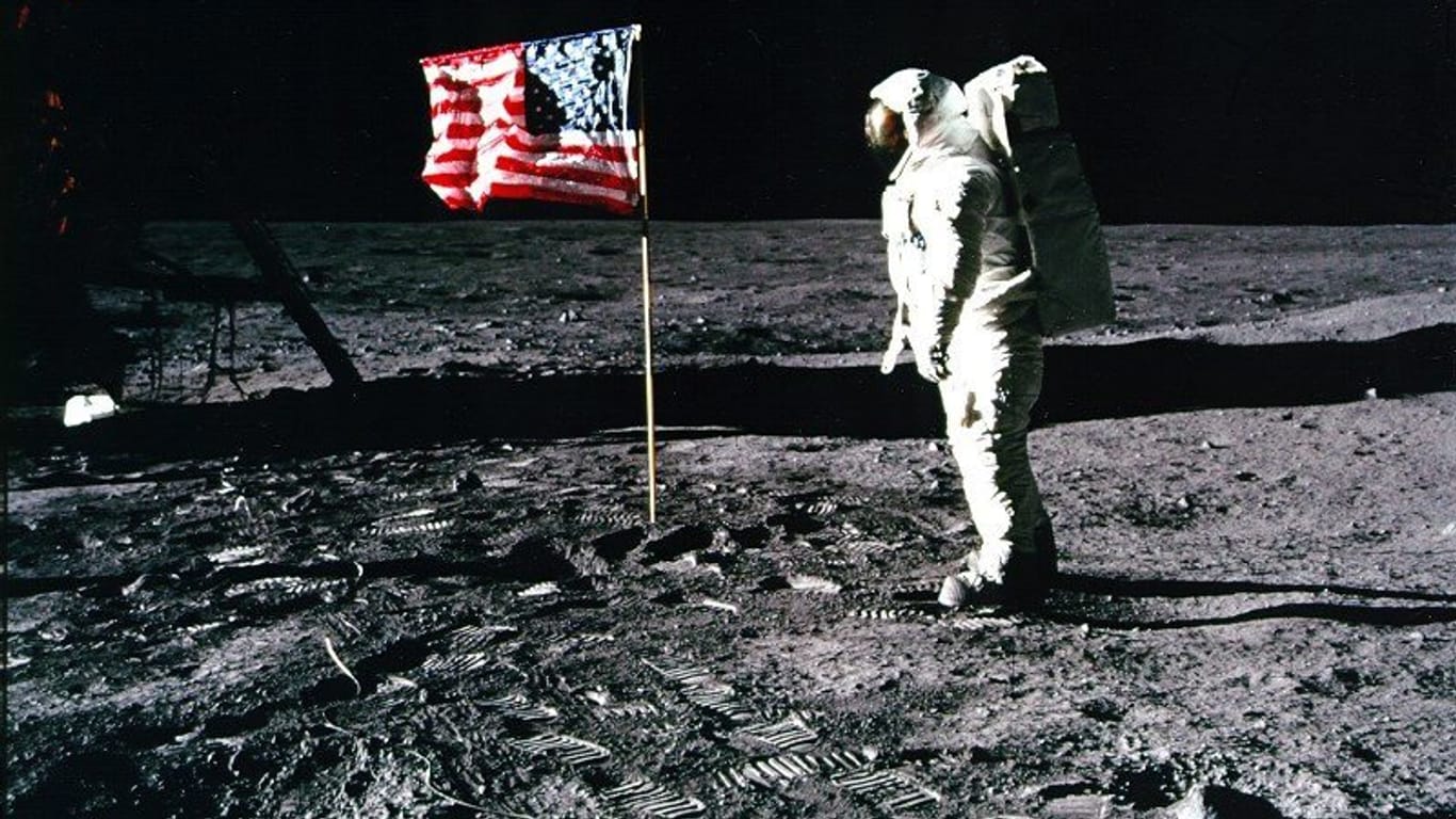 Das Handout-Foto der US-amerikanischen Weltraumbehörde NASA vom 20.07.1969 zeigt den Apollo-11-Astronaut Edwin 'Buzz' Aldrin, der neben einer amerikanischen Flagge auf dem Mond steht: Trump hat angekündigt, dass die USA diesmal nicht nur eine Flagge aufstellt.