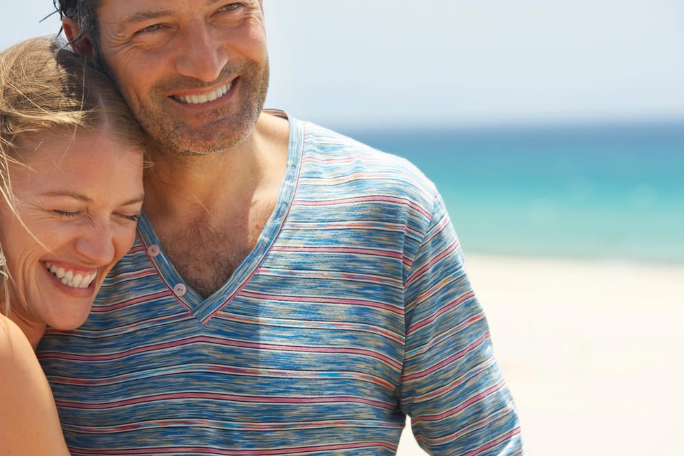 Couple on beach, smiling, close-up