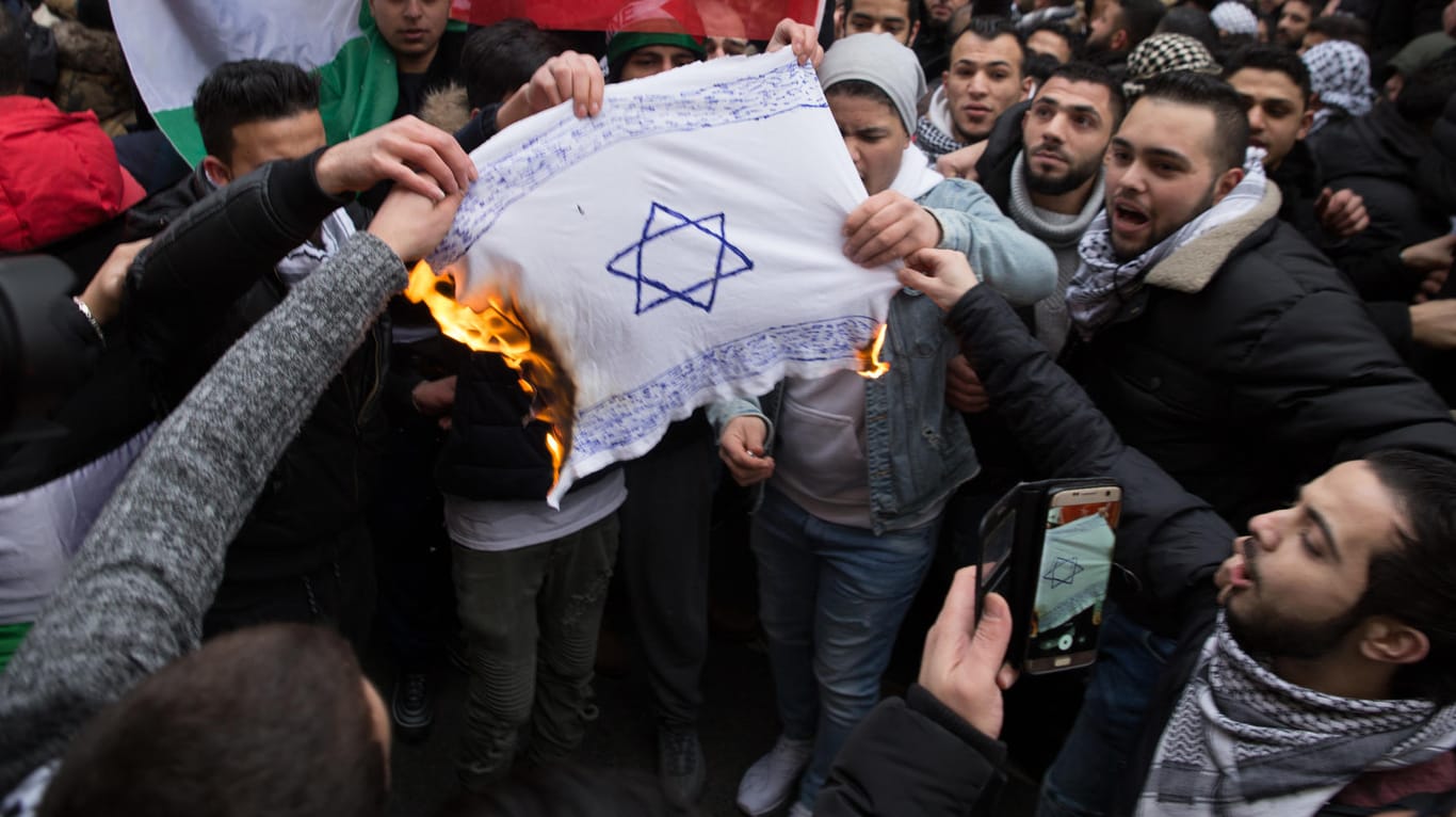 Protest gegen die Anerkennung Jerusalems als israelische Hauptstadt: Demonstranten verbrennen am 10.12.2017 in Berlin eine selbstgemalte Fahne mit einem Davidstern.