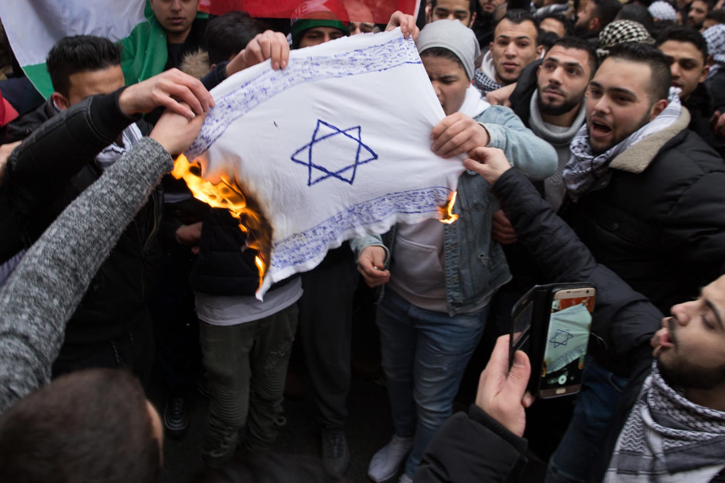 Protest gegen die Anerkennung Jerusalems als israelische Hauptstadt: Demonstranten verbrennen am 10.12.2017 in Berlin eine selbstgemalte Fahne mit einem Davidstern.