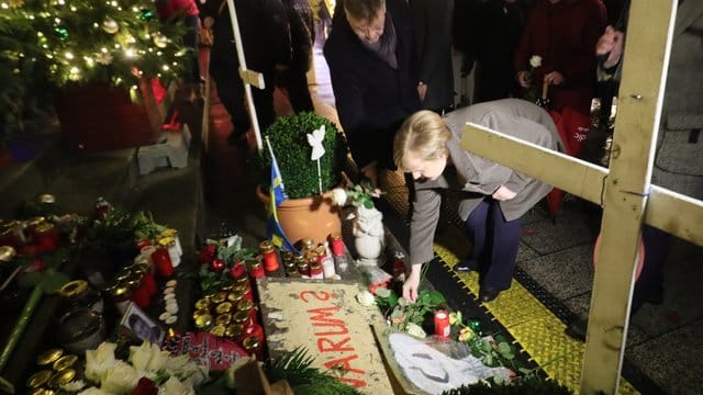 Zum Gedenken an die Opfer des Terroranschlags: Angela Merkel legt eine weiße Rose am Breitscheidplatz in Berlin nieder.