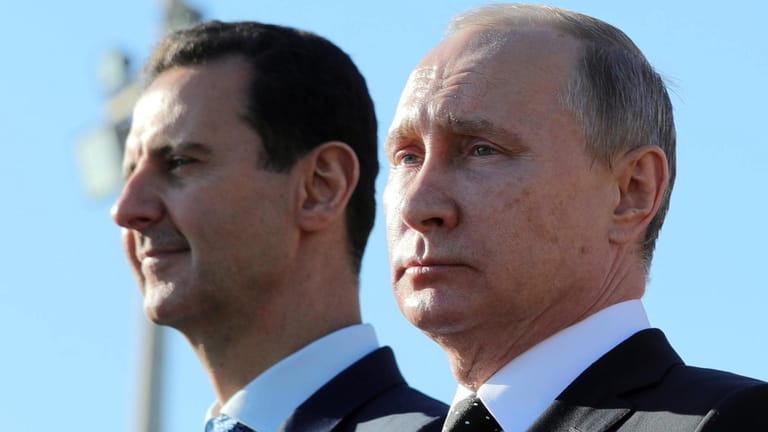 Putin (r.) und der syrische Präsident Baschar al-Assad schauen sich in Hmeimim (Syrien) auf der Luftwaffenbasis Hmeimim eine Truppenübung an.