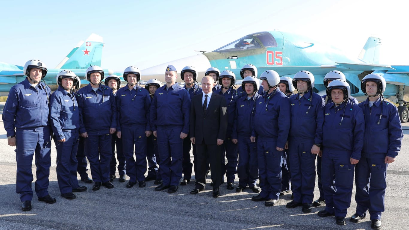 Putin posiert mit russischen Militärpiloten auf der russischen Luftwaffenbasis Hamaimim in der Provinz Latakia in Syrien.