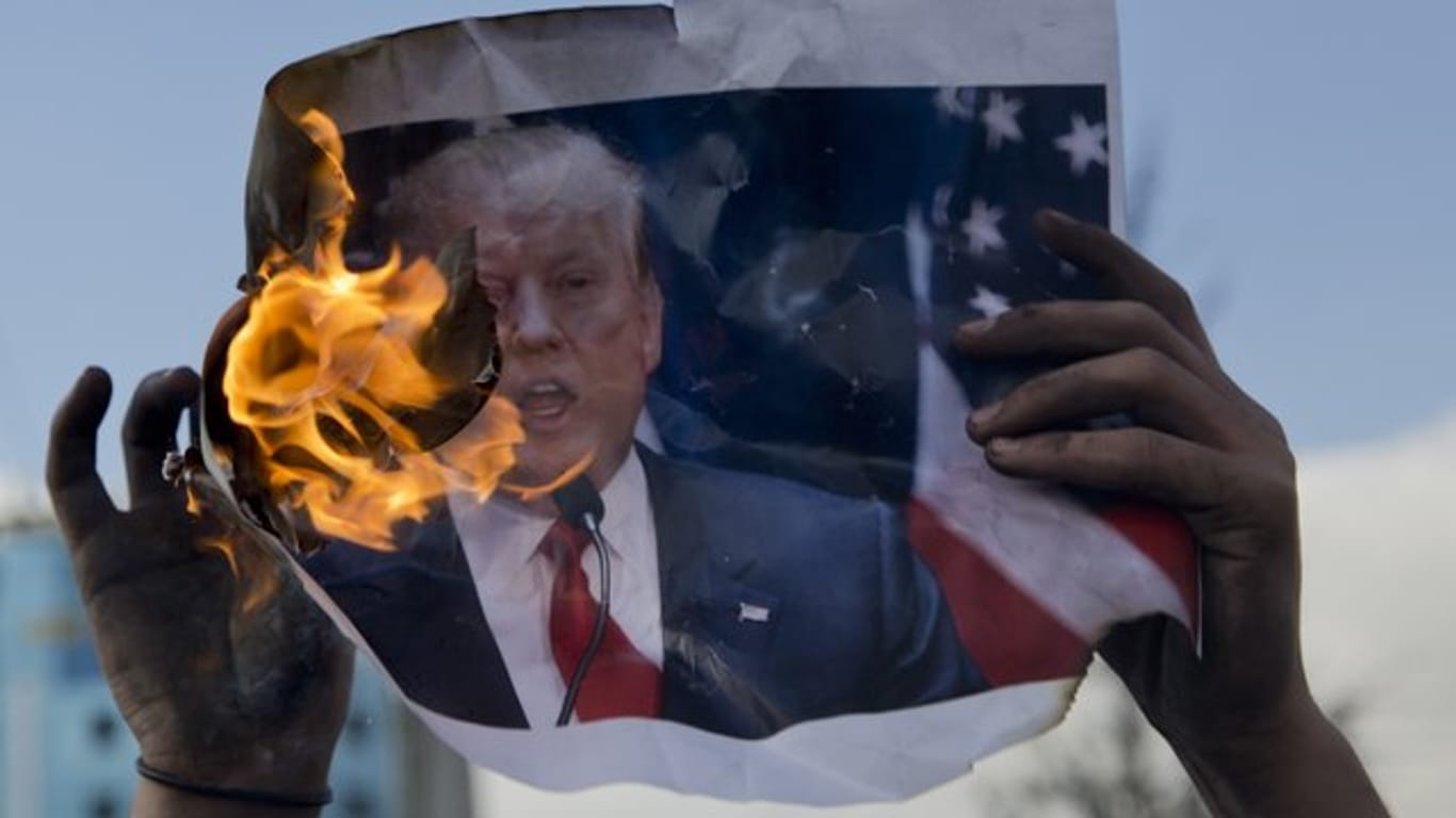 Feindbild Donald Trump: Ein palästinensischer Demonstrant verbrennt in Ramallah im Westjordanland ein Bild des US-Präsidenten.