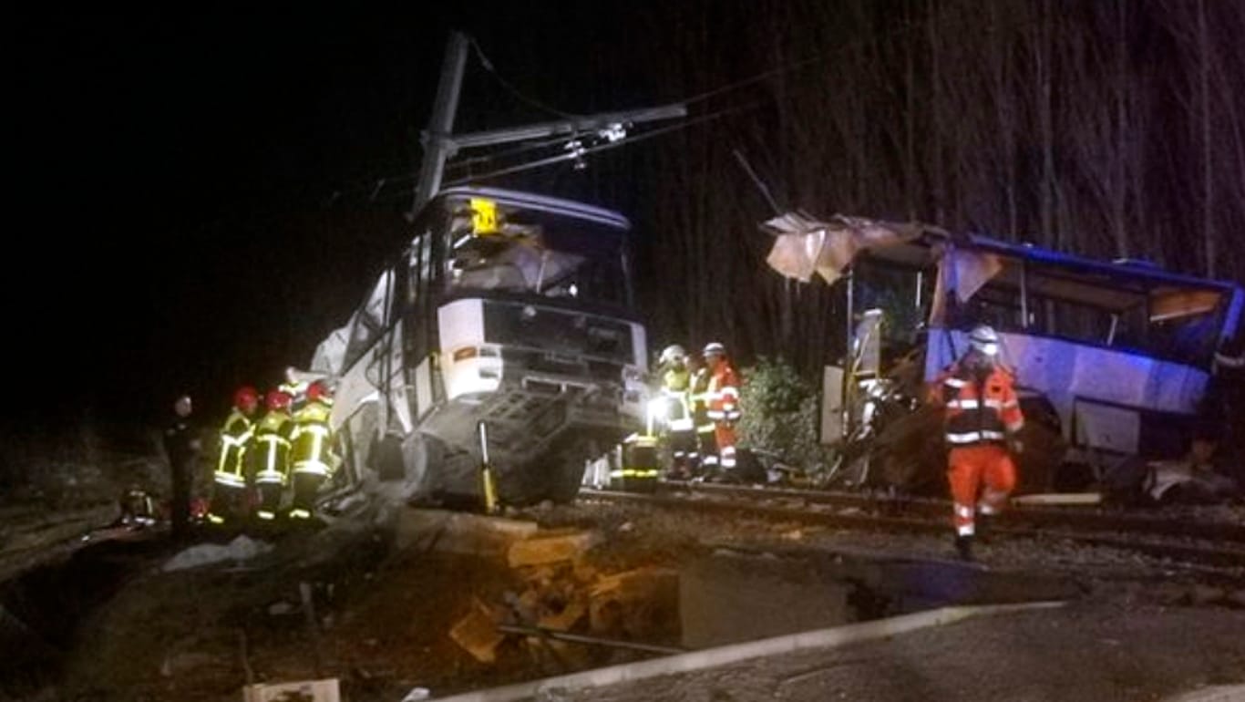 Einsatzkräfte an der Unglückstelle: In Frankreich sind mindestens vier Kinder gestorben, als ein Schulbus mit einem Regionalzug zusammenprallte.