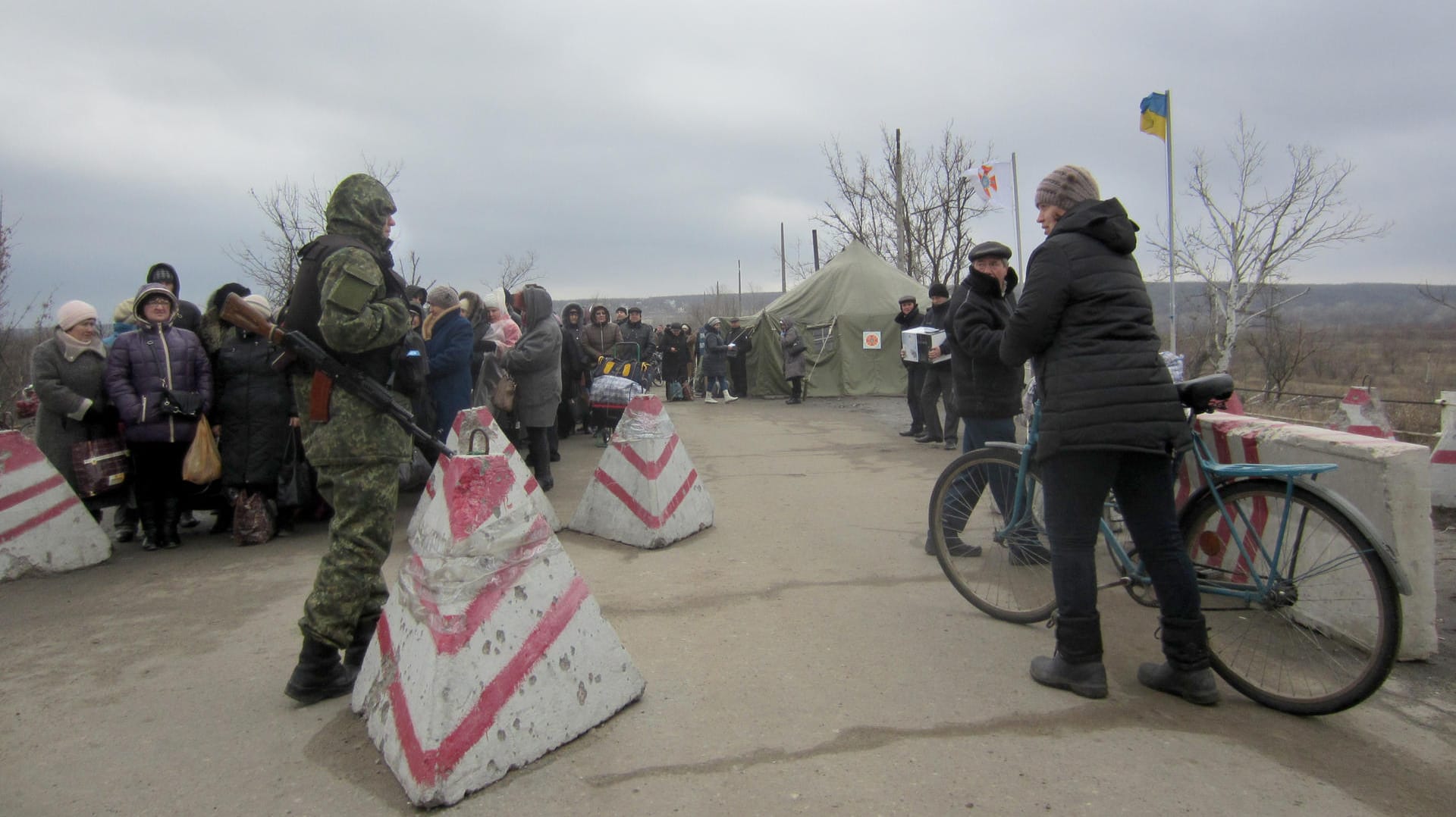 Eine Passantin spricht mit einem ukrainischen Grenzsoldaten an einem Kontrollpunkt zwischen Regierungs- und Rebellengebiet in der Ostukraine.