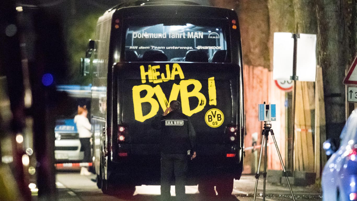 Ein Beamter des Landeskriminalamtes untersucht in Dortmund den Mannschaftsbus der Fußballmannschaft von Borussia Dortmund, bei dem es drei Explosionen gegeben hatte.