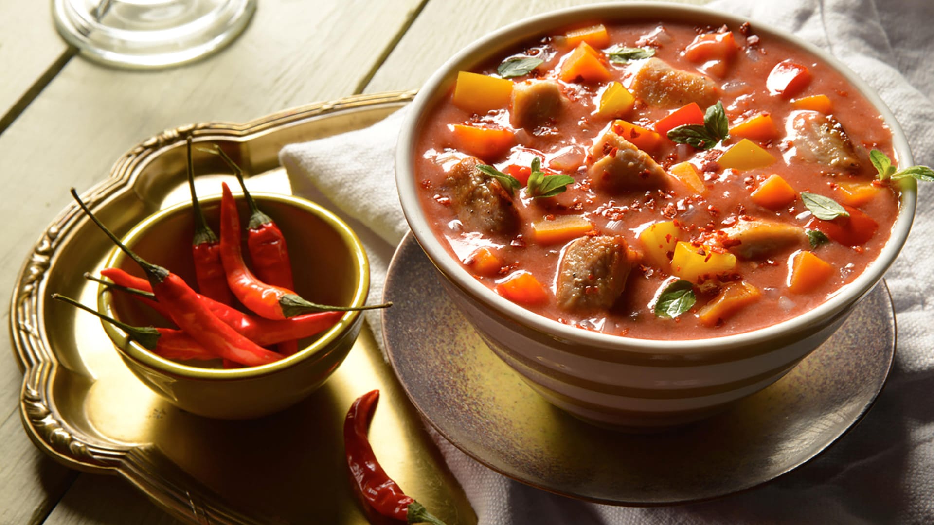 Süßkartoffeln werden mit Hähnchenbrust und Schweinegulasch zusammen in einer Chili-Tomatensoße gekocht.